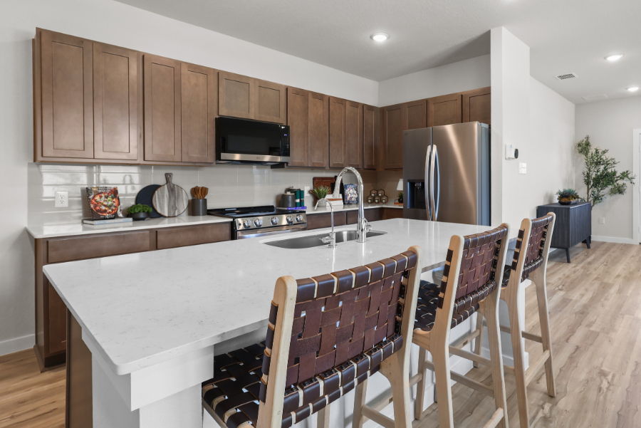 A kitchen with a bar and chairs.