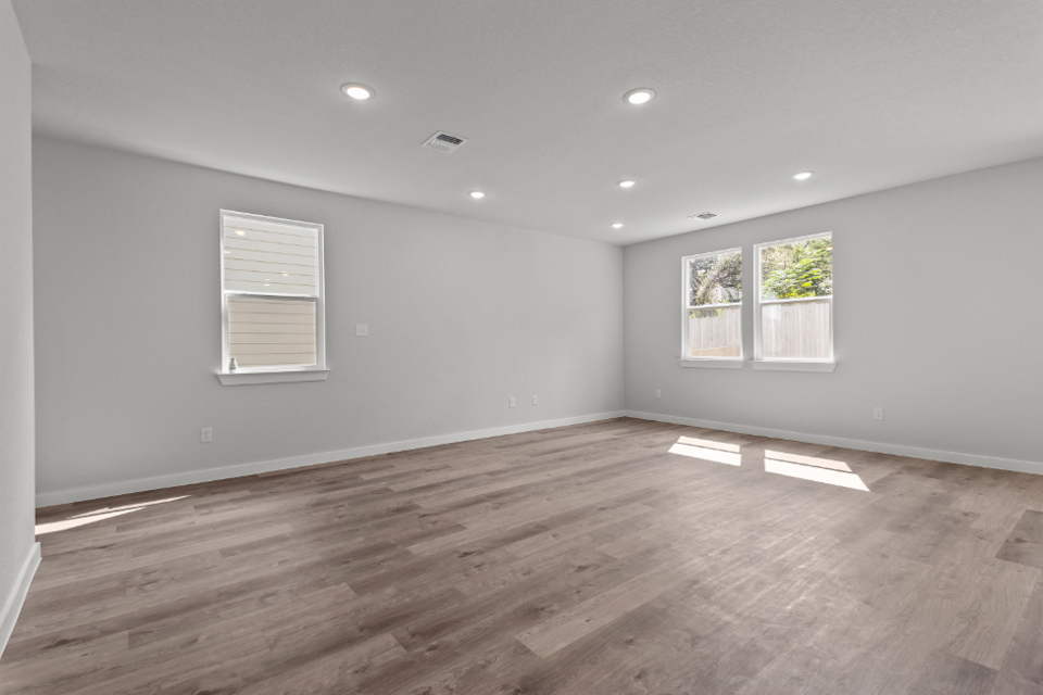 A room with a wood floor and windows.