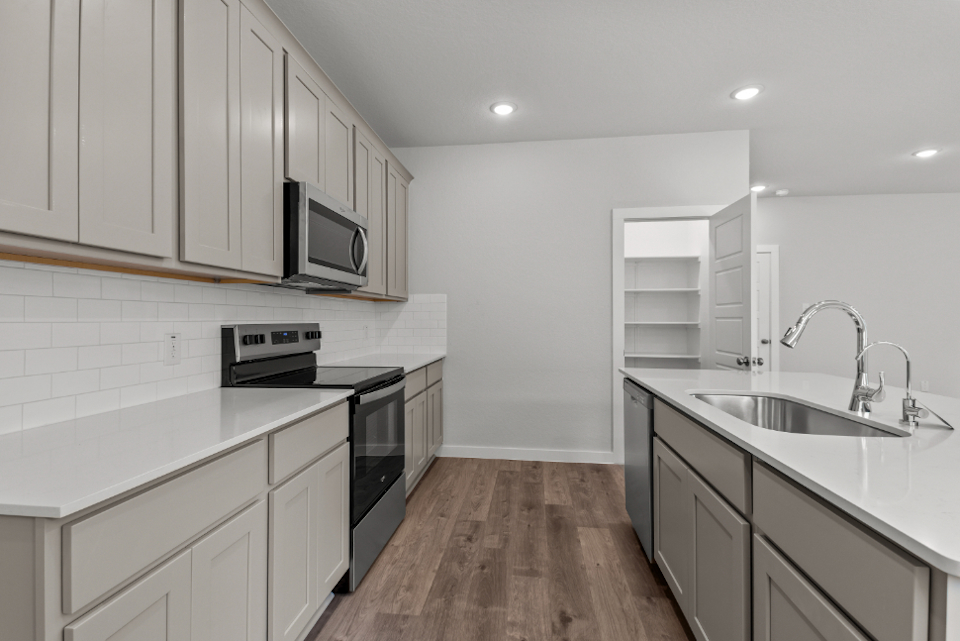 A kitchen with white cabinets.
