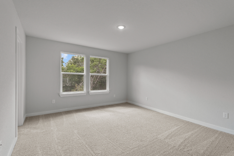 A room with a window and a white wall.