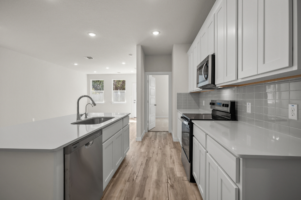 A kitchen with white cabinets.
