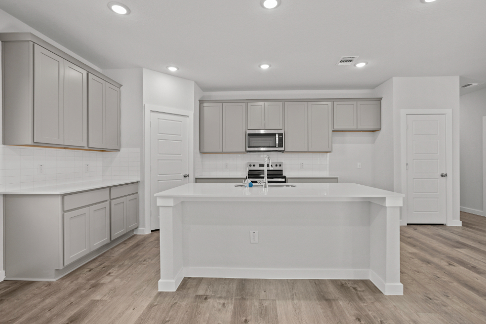 A kitchen with white cabinets.