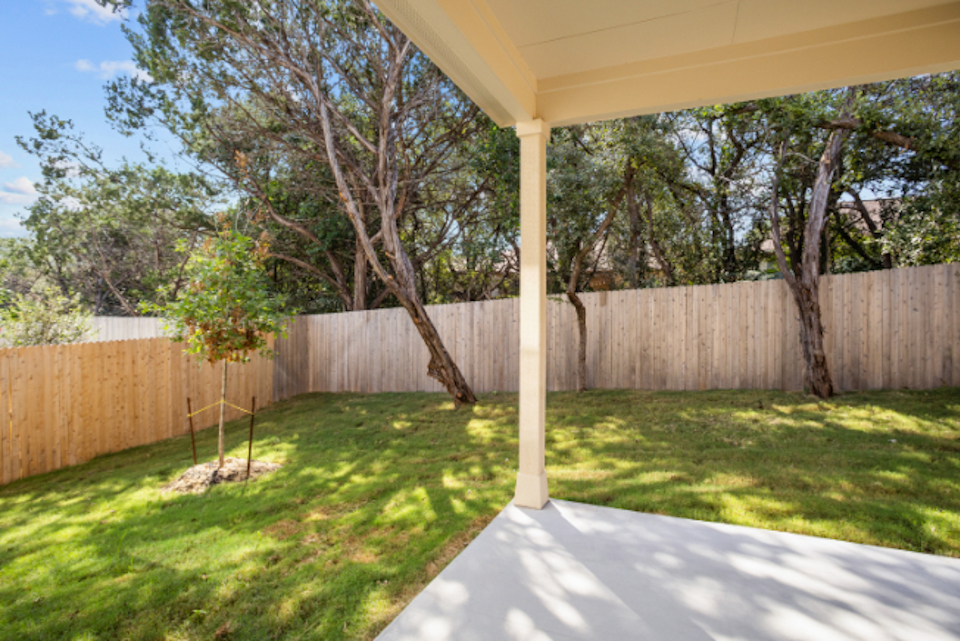 A backyard with a fence and trees.