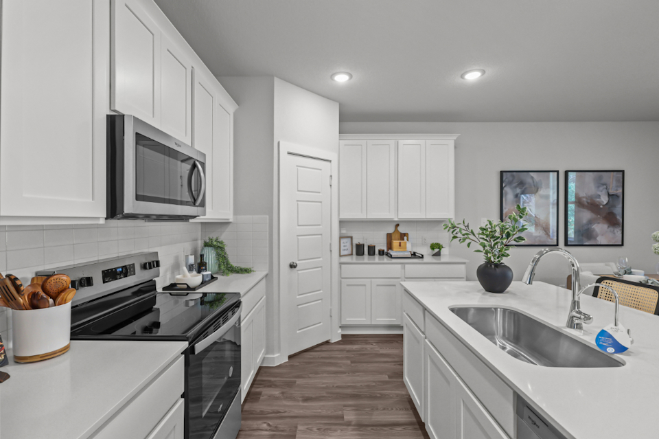 A kitchen with white cabinets.