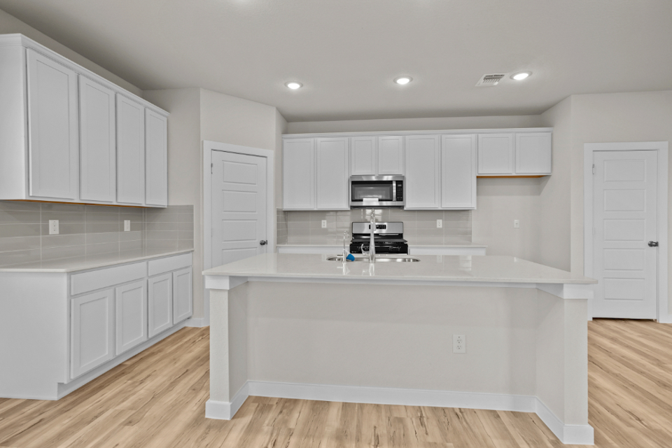 A kitchen with white cabinets.