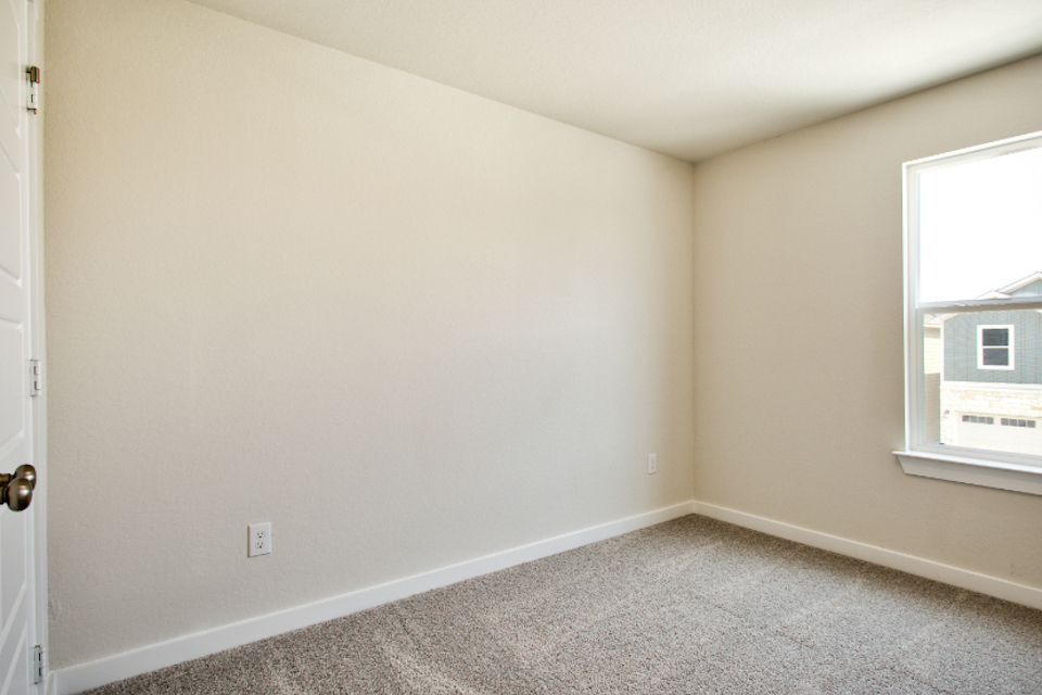 A room with a carpet and a window.