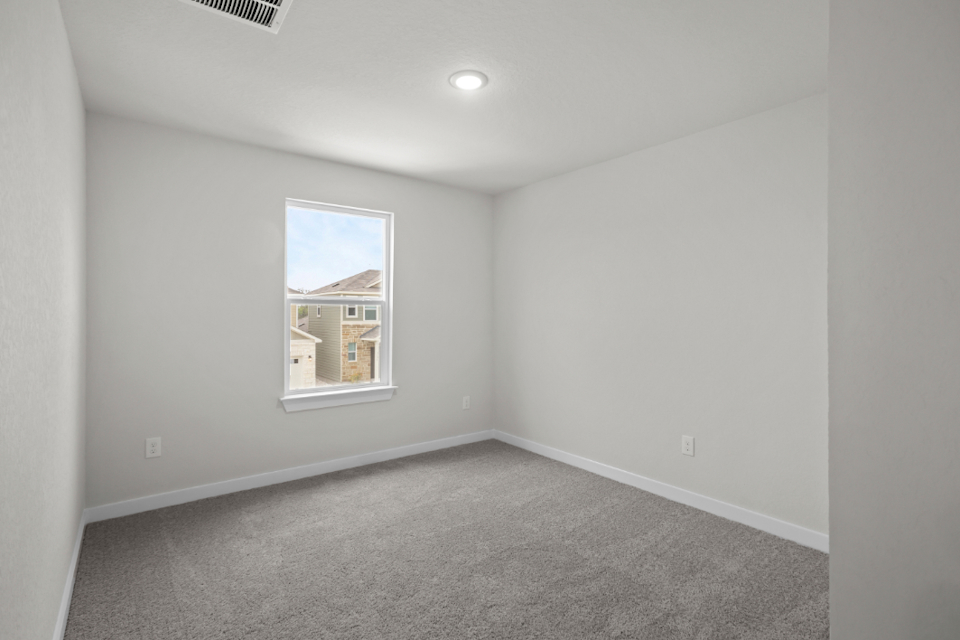 A room with a window and carpet.