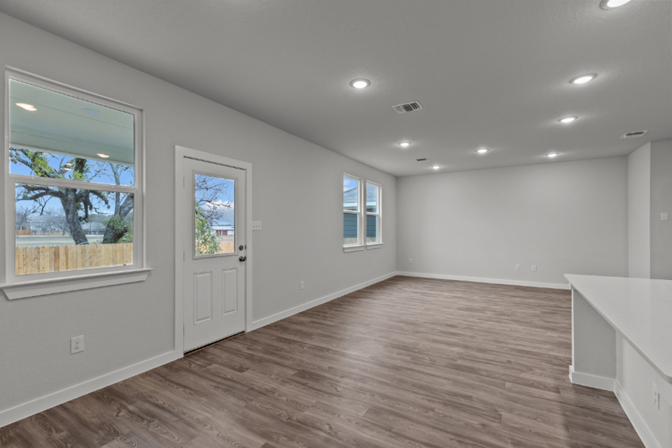 A room with a wood floor and windows.