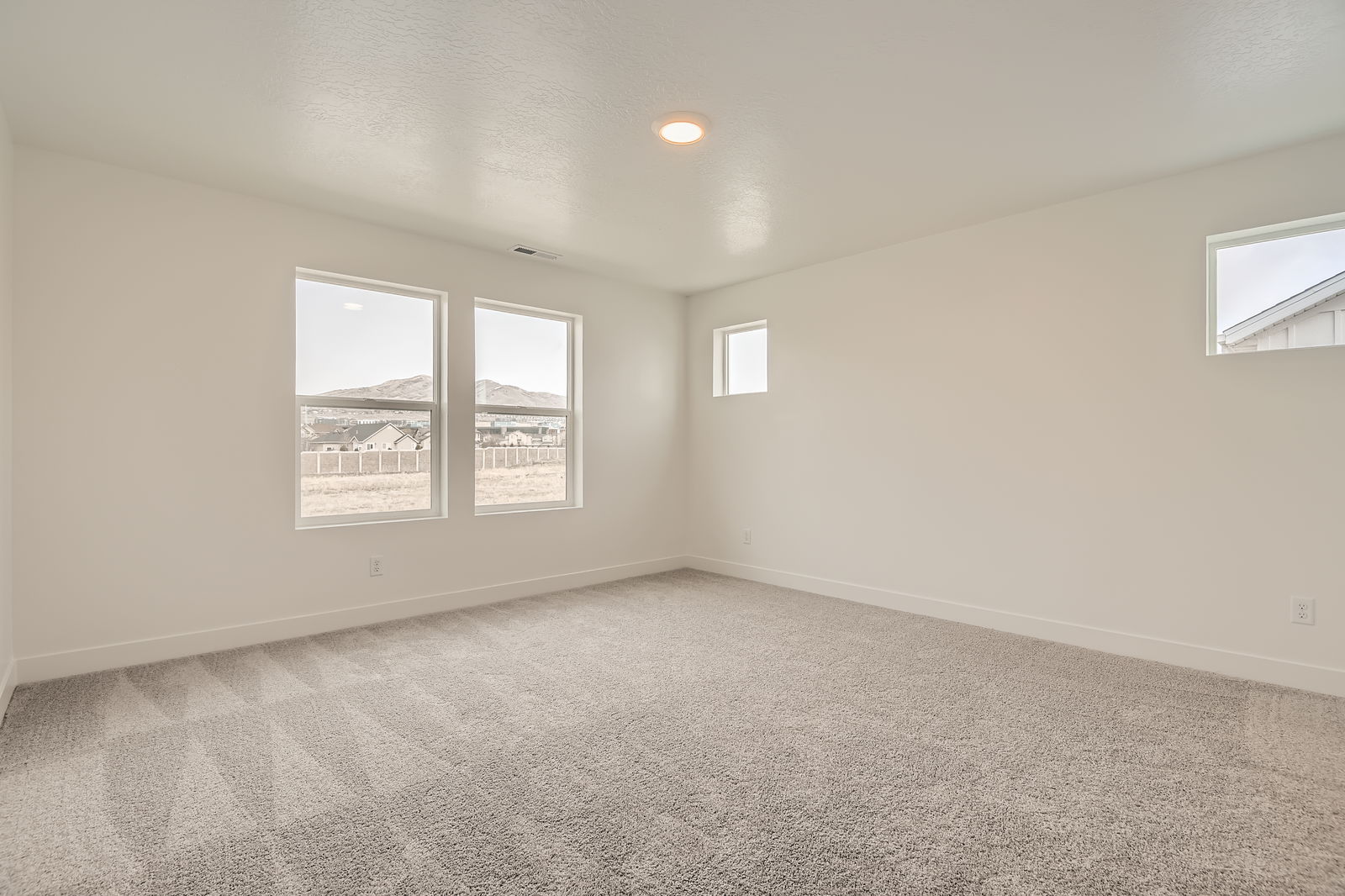A room with a window and a view of a city.