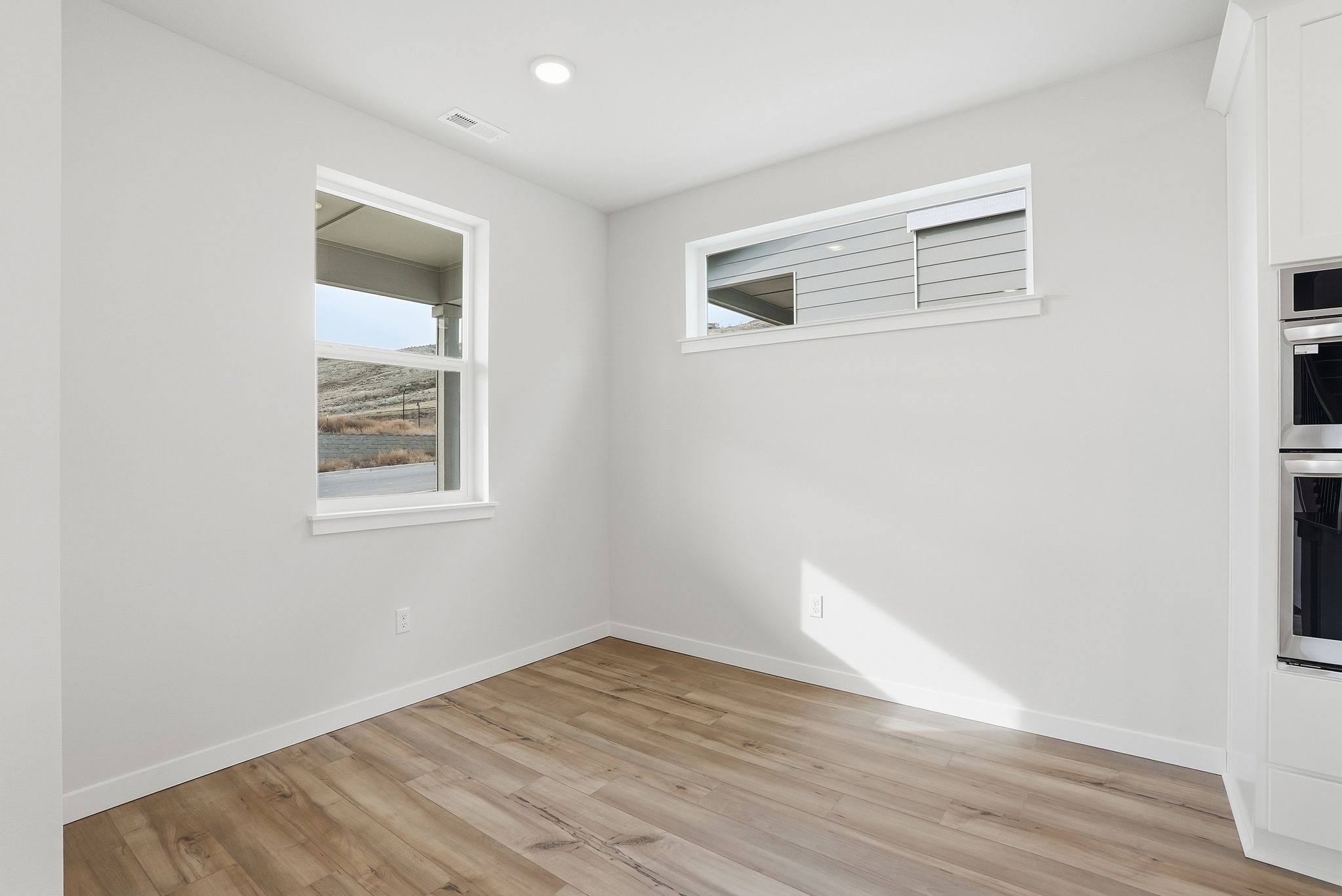 A room with a wood floor and a window.