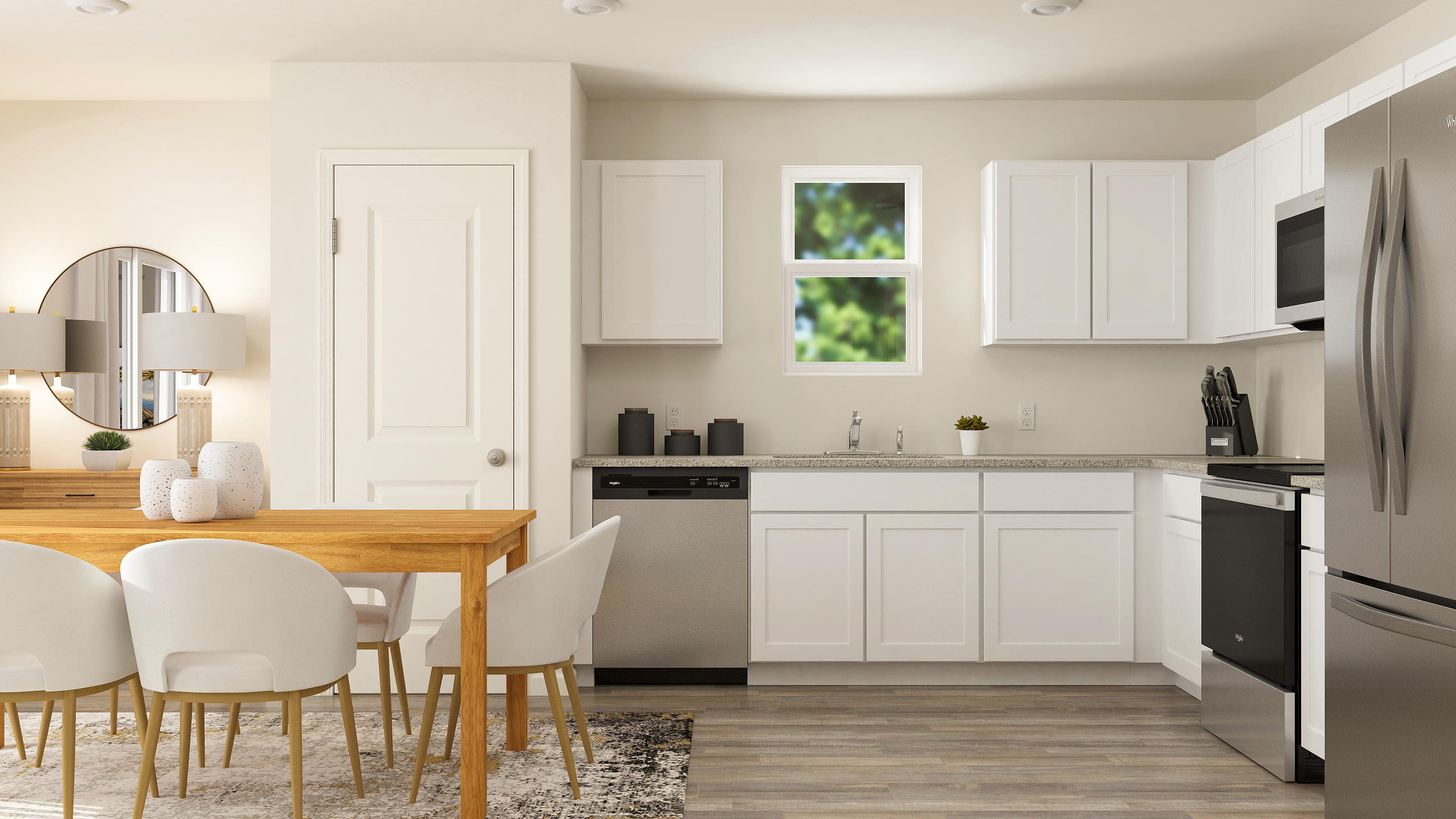 A kitchen with white cabinets.