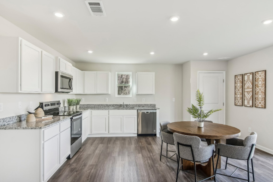 A kitchen with white cabinets.