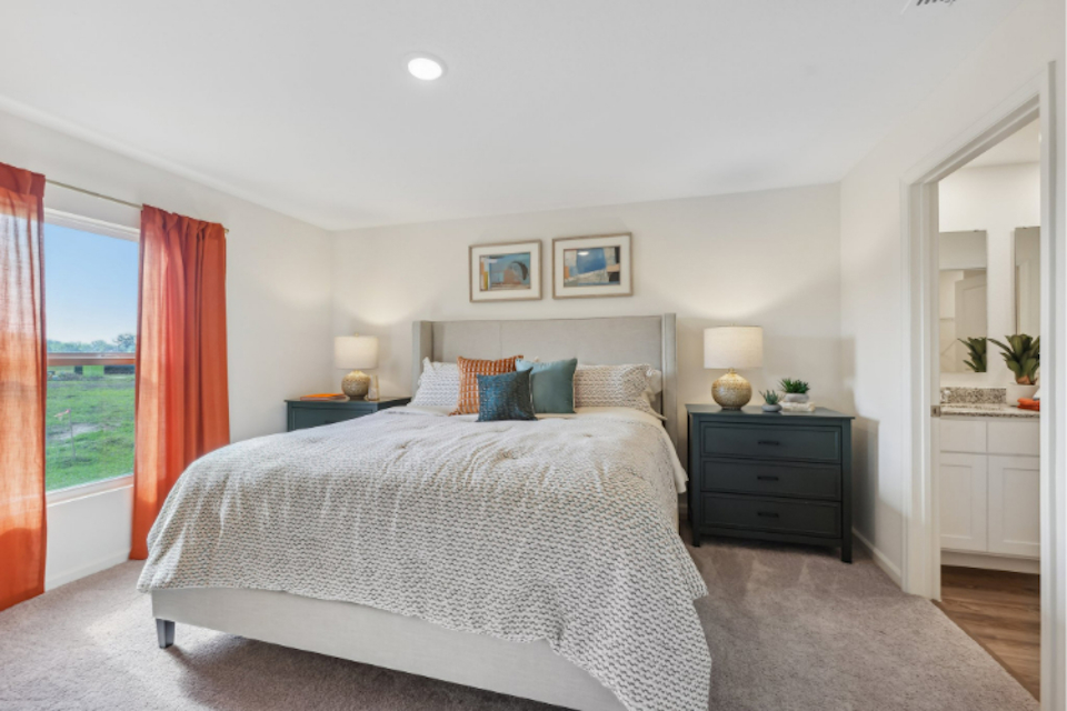A bedroom with a large window.