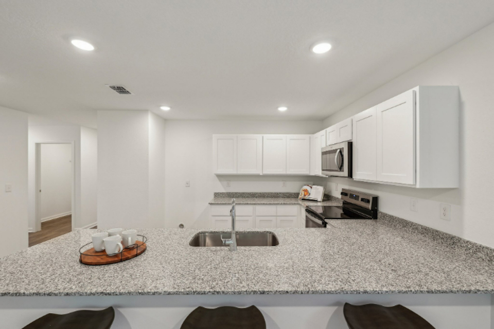 A kitchen with white cabinets.
