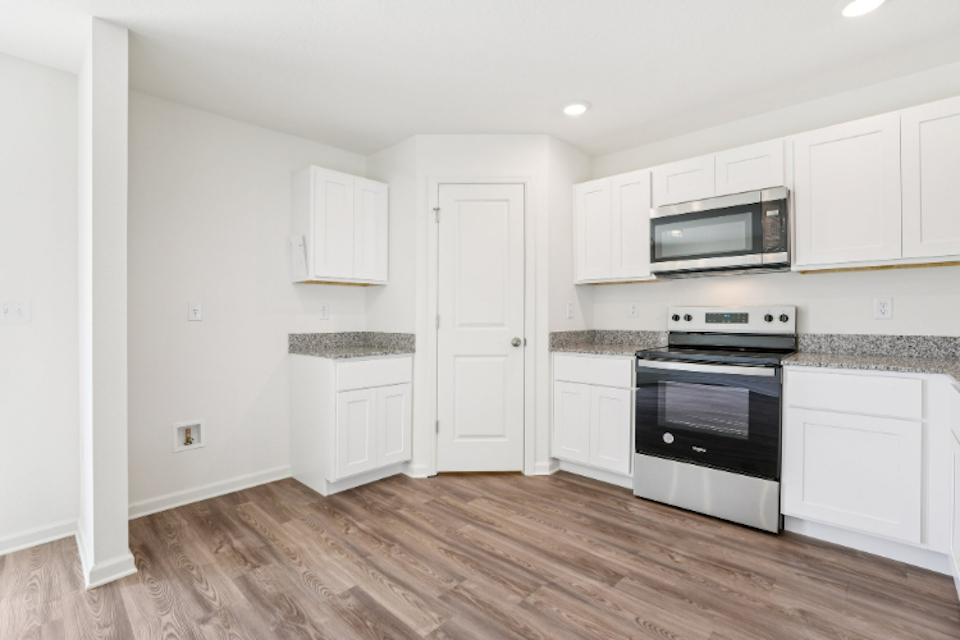 A kitchen with white cabinets.