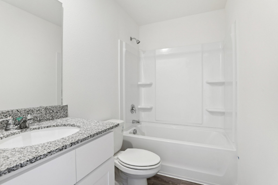 A bathroom with a tub sink and toilet.