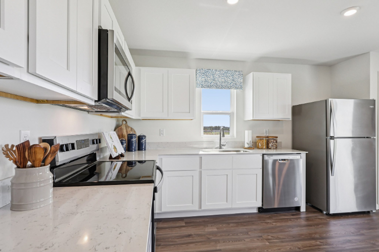 A kitchen with white cabinets.