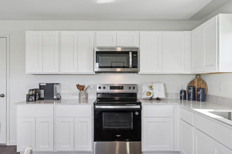 A kitchen with white cabinets.