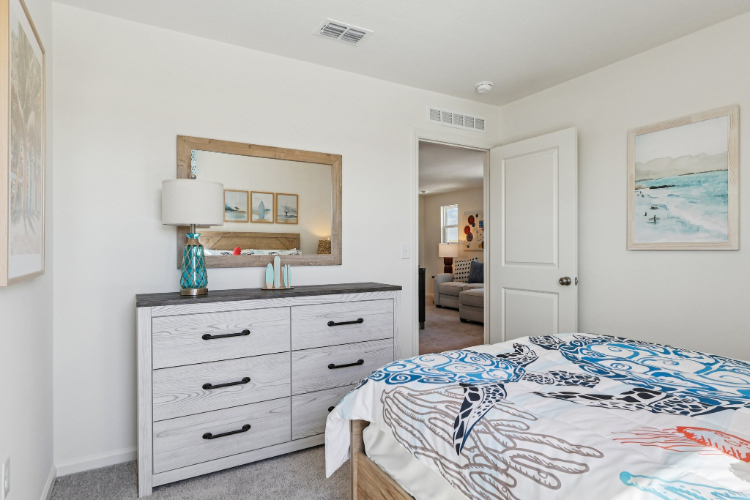 A bedroom with a bed and dresser.