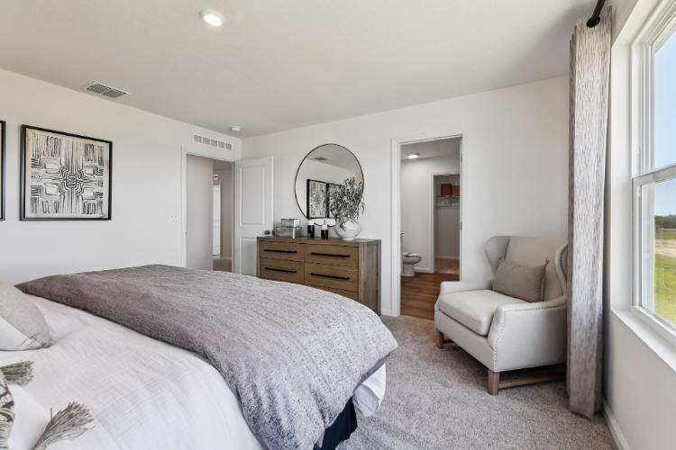 A bedroom with a bed and a chair.