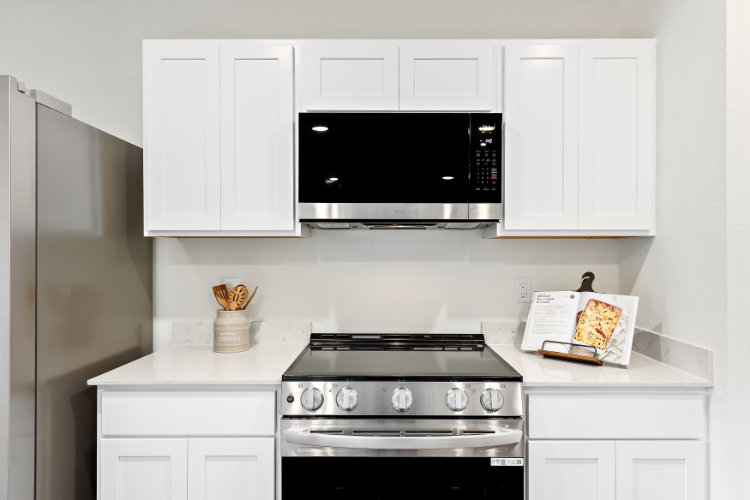 A kitchen with white cabinets.