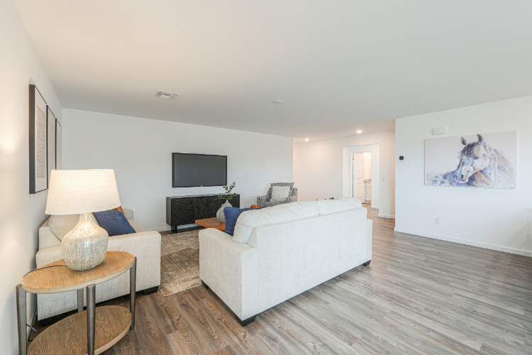 A living room with a white couch and a white table.
