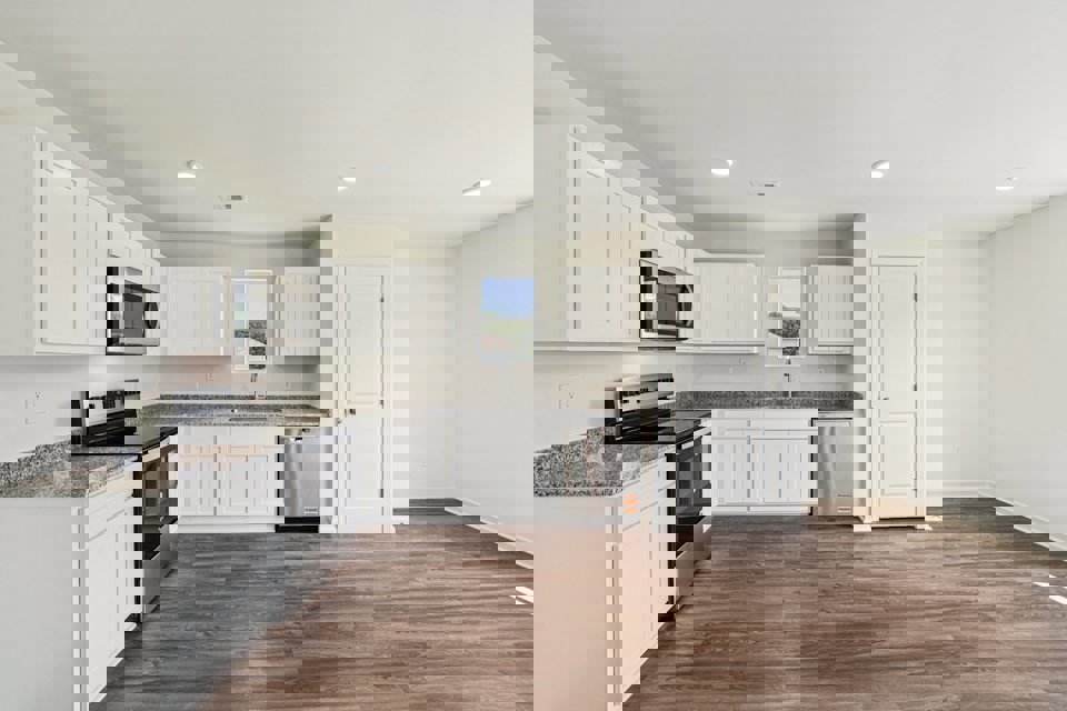 A kitchen with white cabinets.