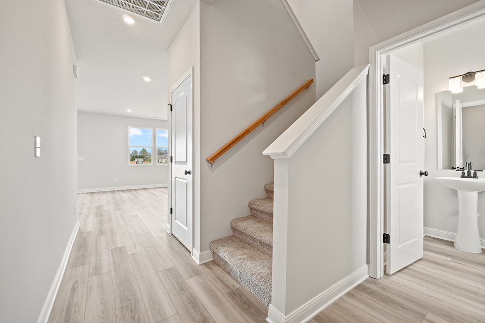 A bathroom with a wood staircase.