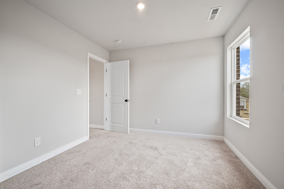 A room with a carpet and a door.