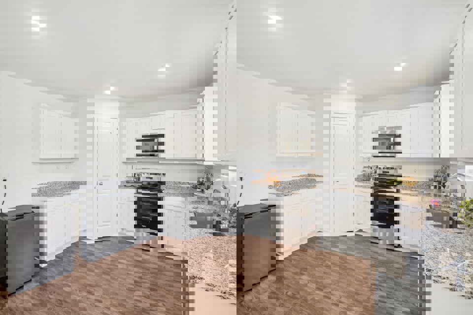 A kitchen with white cabinets.