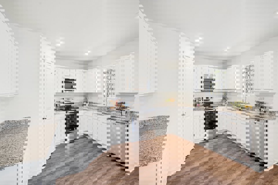 A kitchen with white cabinets.