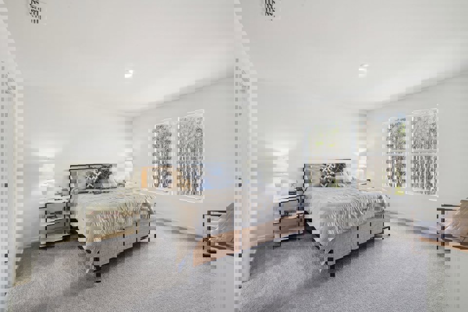 A bedroom with a bed and lamps.