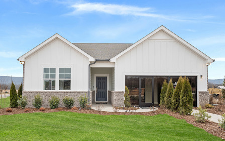 A house with a large front yard with Southfork Ranch in the background.