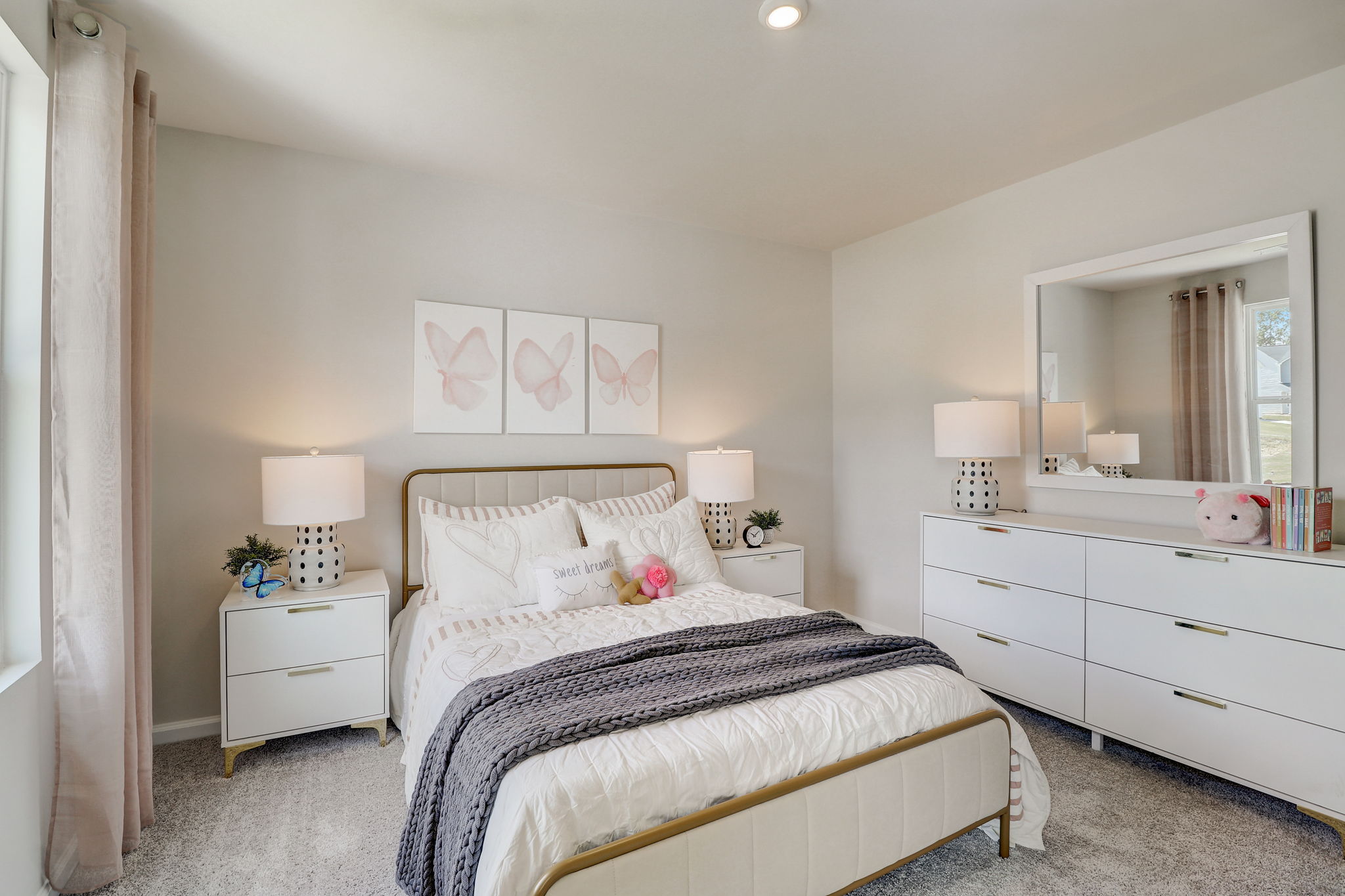 A bedroom with a bed and lamps.