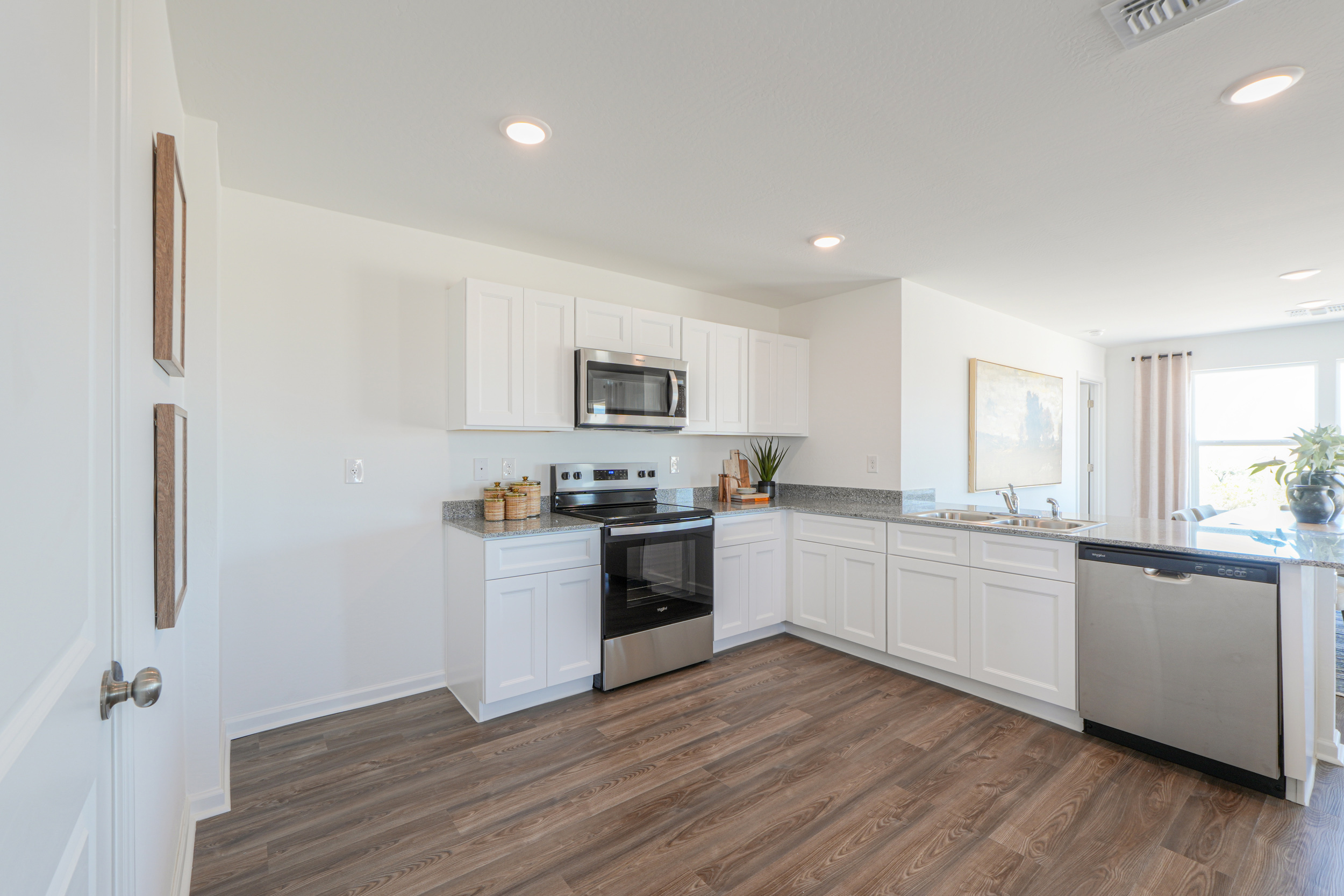 A kitchen with white cabinets.