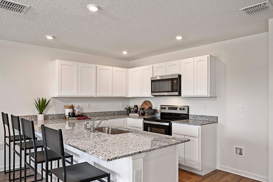 A kitchen with white cabinets.
