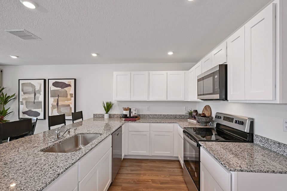 A kitchen with white cabinets.