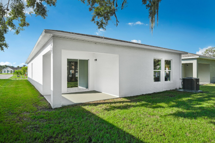 A white house with a grass yard.