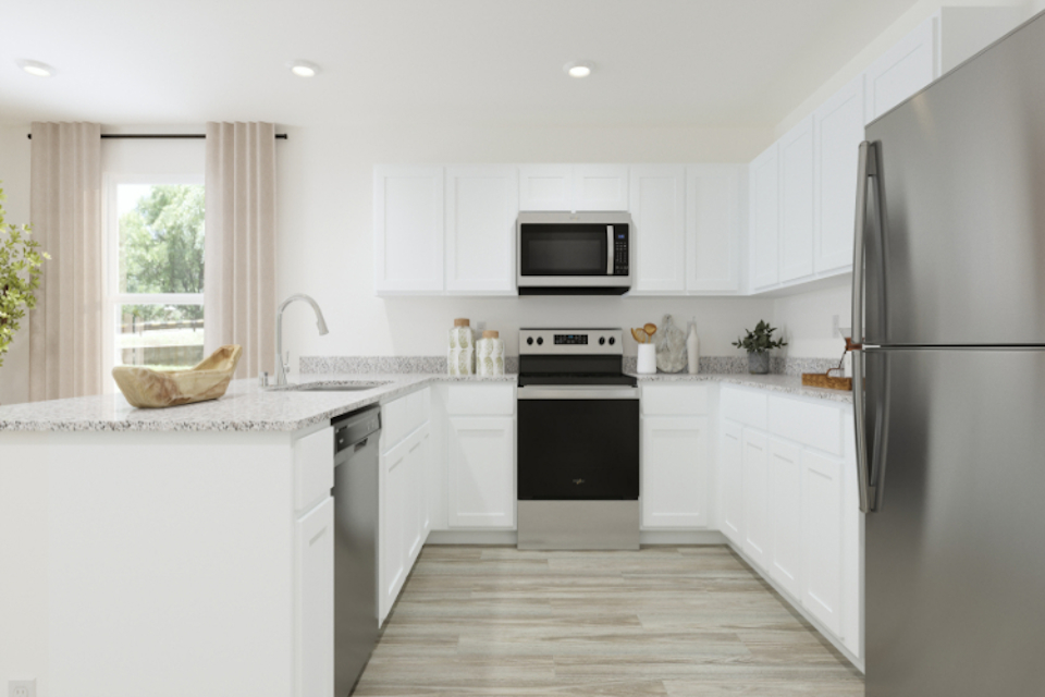 A kitchen with white cabinets.