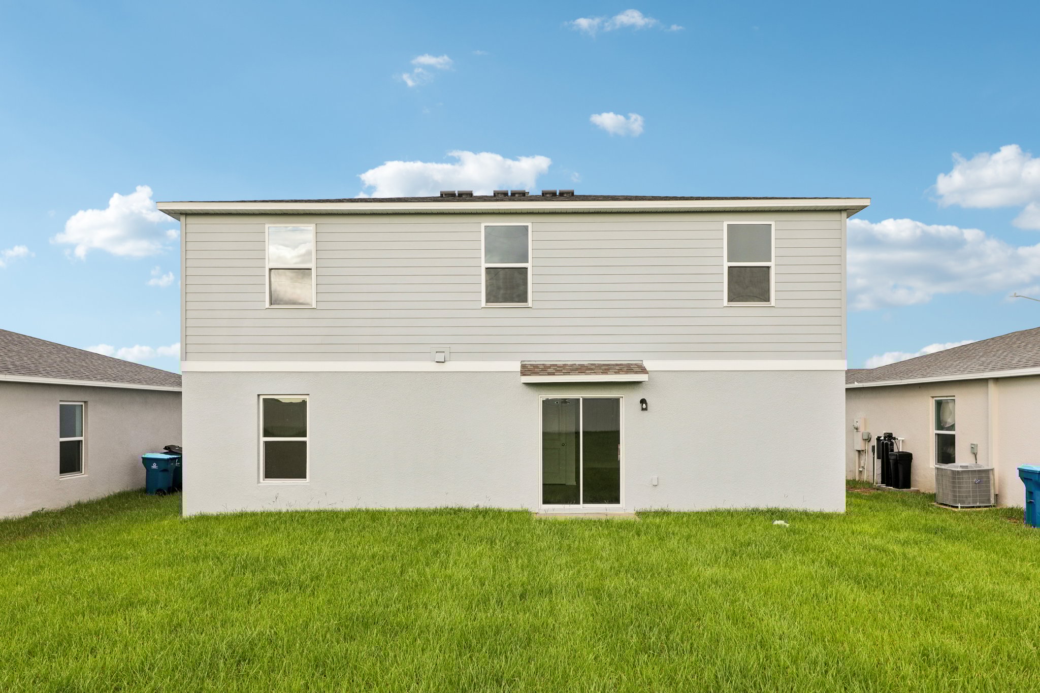 A white house with a green lawn.