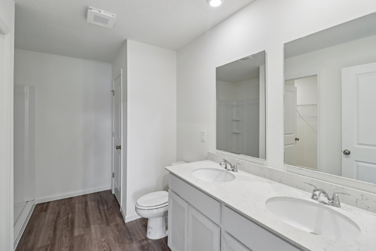 A bathroom with a toilet sink and mirror.