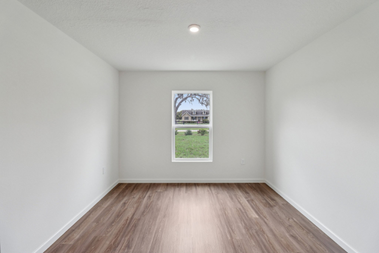 A room with a wood floor and a window.