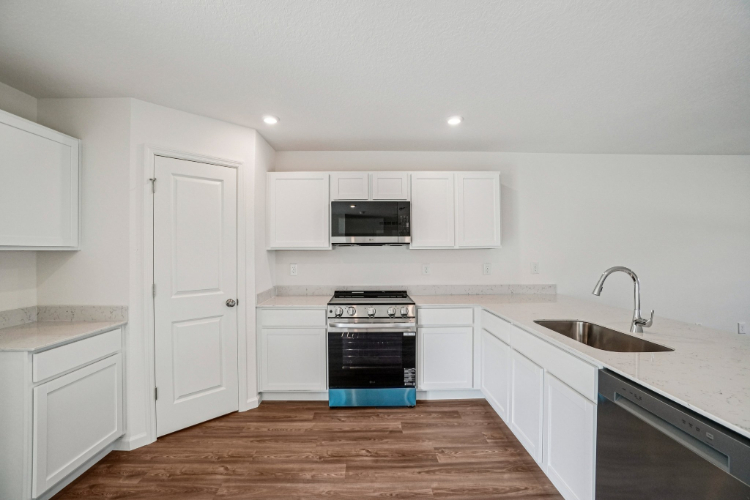 A kitchen with white cabinets.