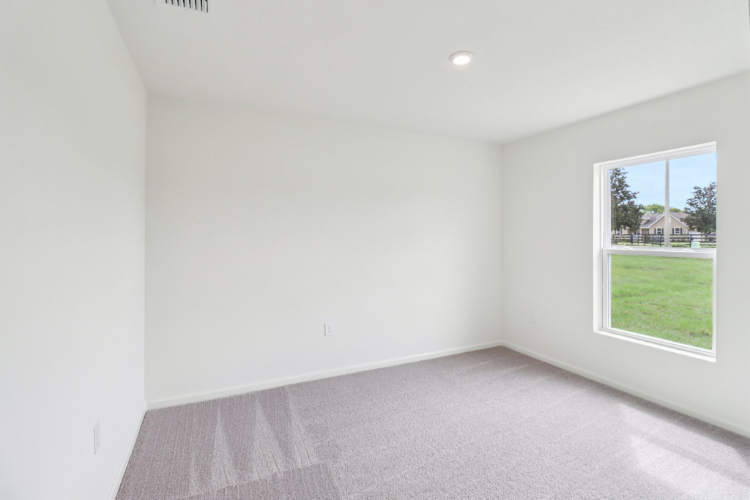 A room with a window and a carpet.