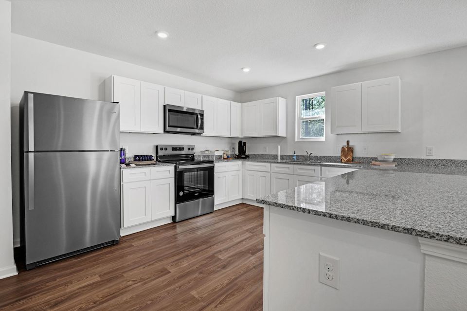 A kitchen with white cabinets.