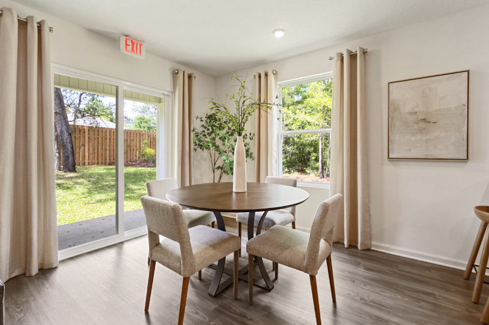 A dining room with a table and chairs.