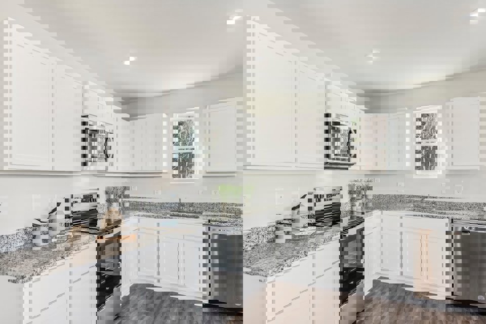 A kitchen with white cabinets.