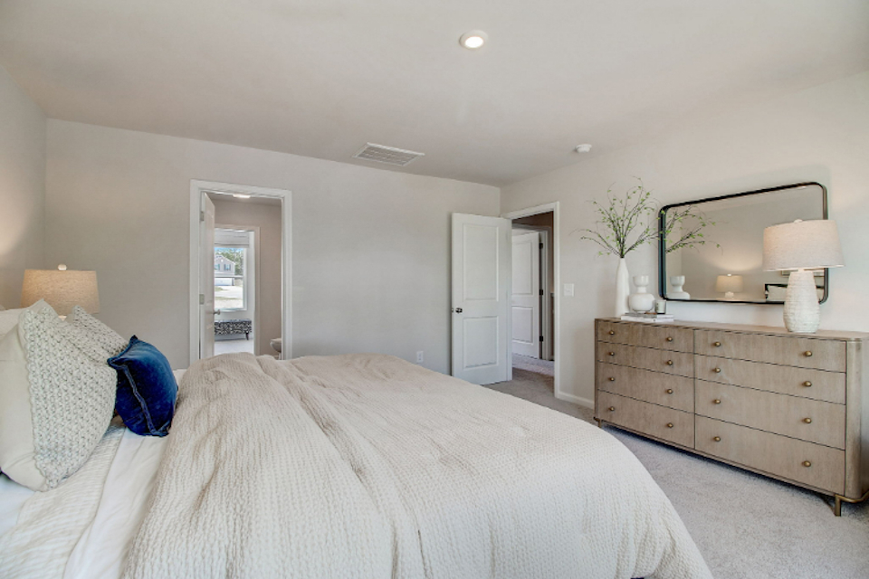 A bedroom with a bed and dresser.