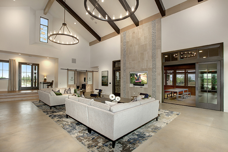 A large living room with a large white couch and a large television.